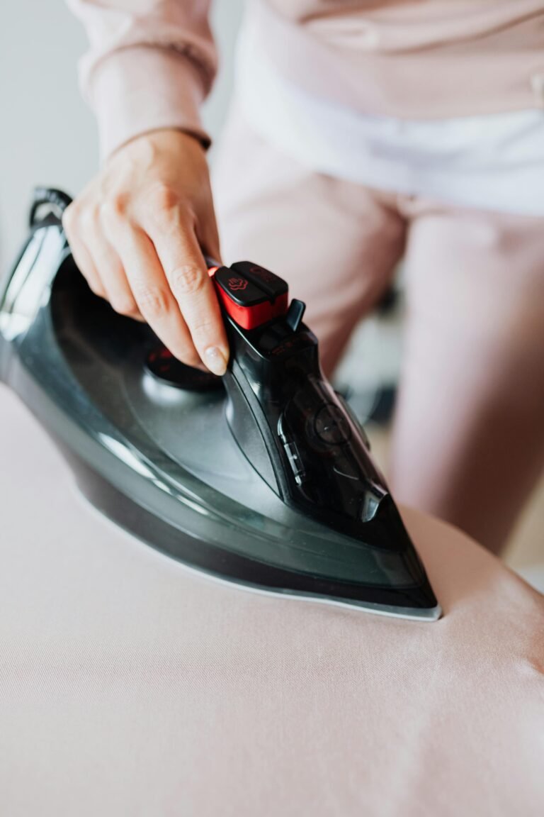 Person Using a Black Clothes Iron